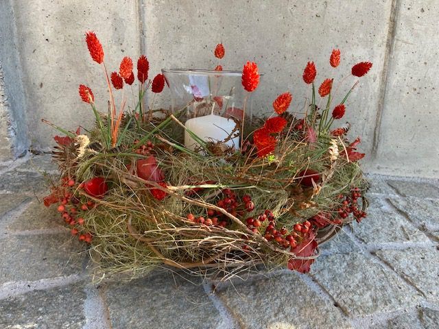 Herbstlicher Blumenkranz mit roten Beeren und Kerze