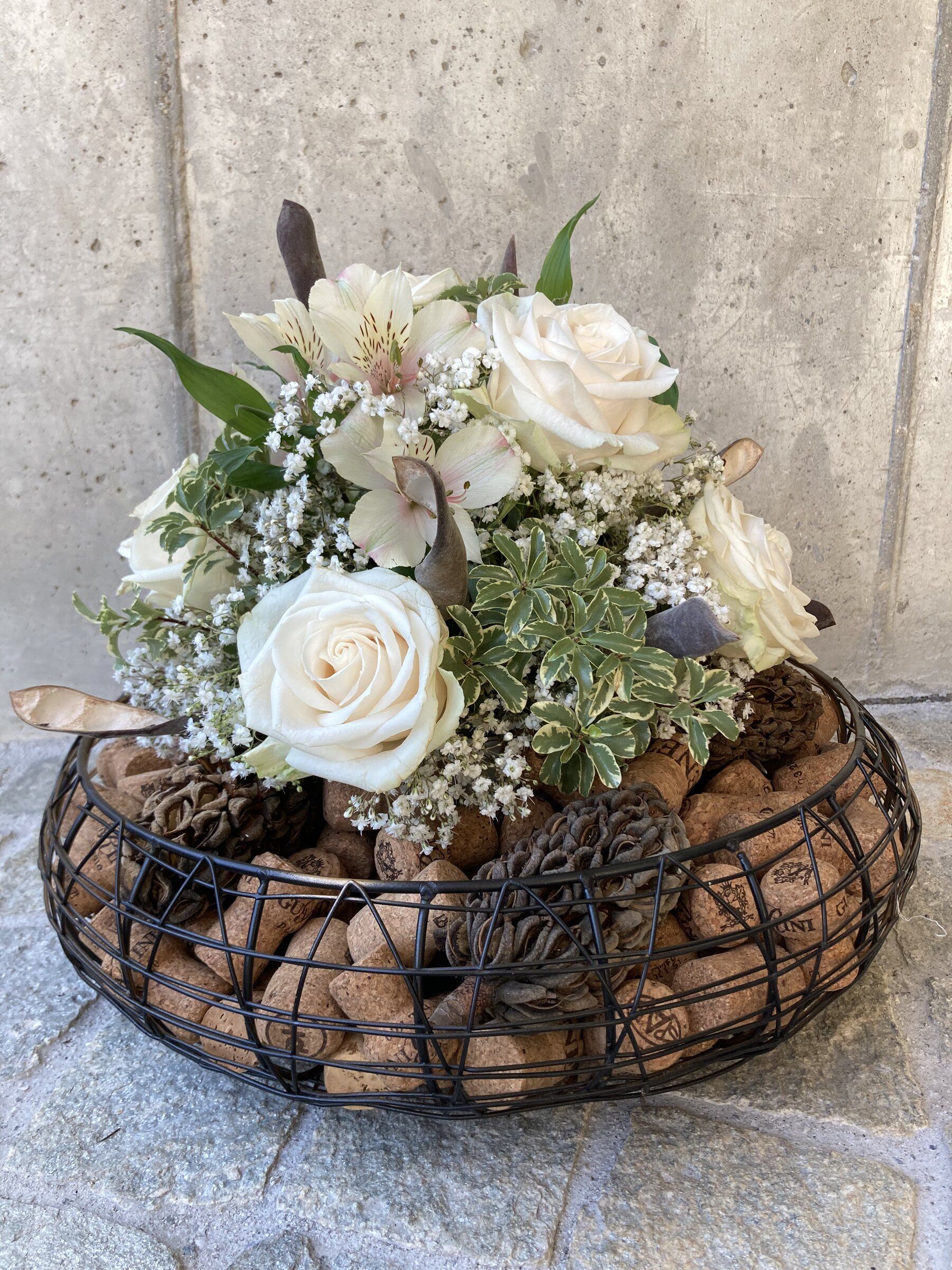 Gesteck im Drahtkorb mit weissen Rosen, Schleierkraut und Korken