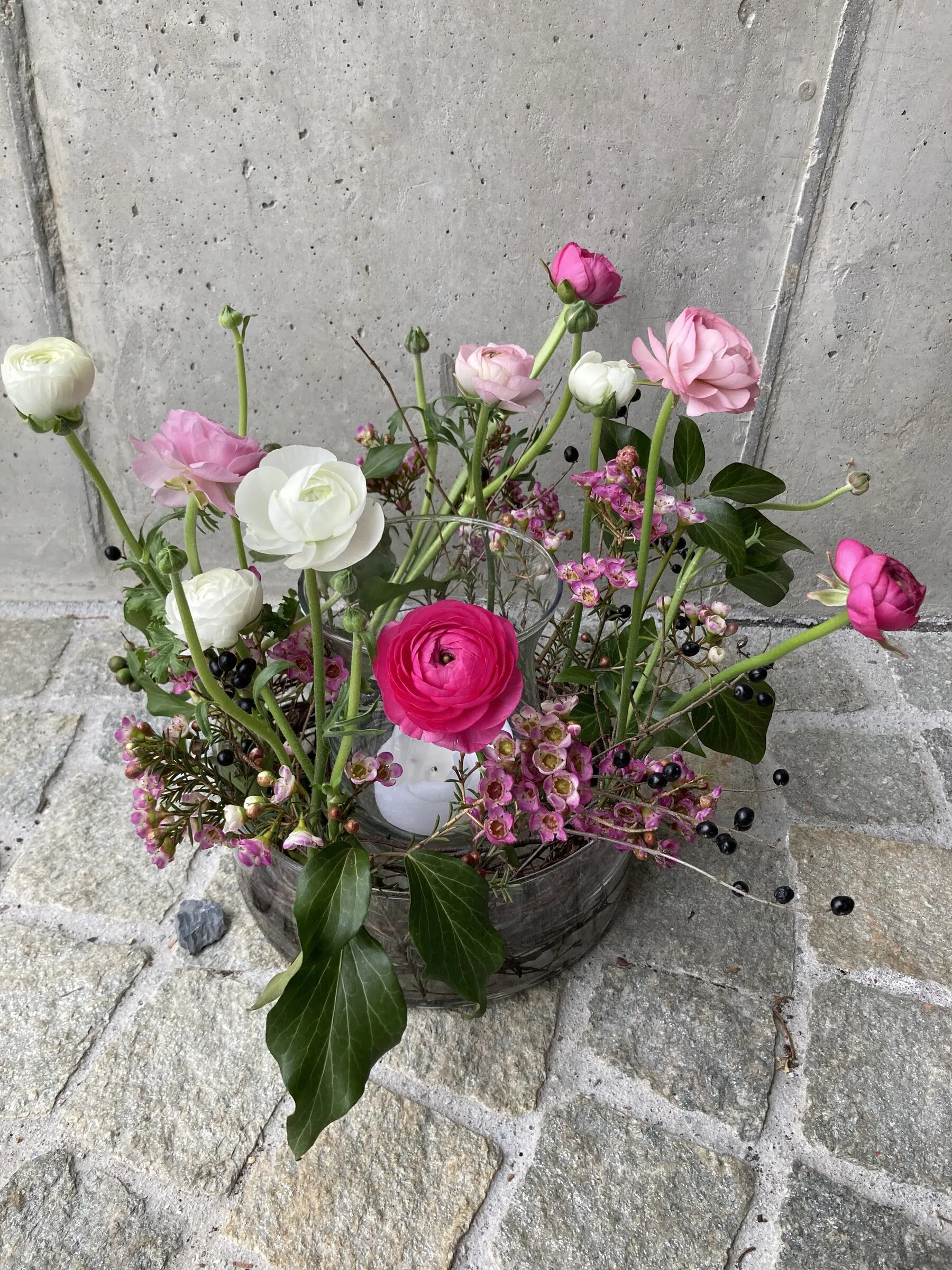 Glasschale mit pinken Ranunkeln, Wachsblumen und Efeu