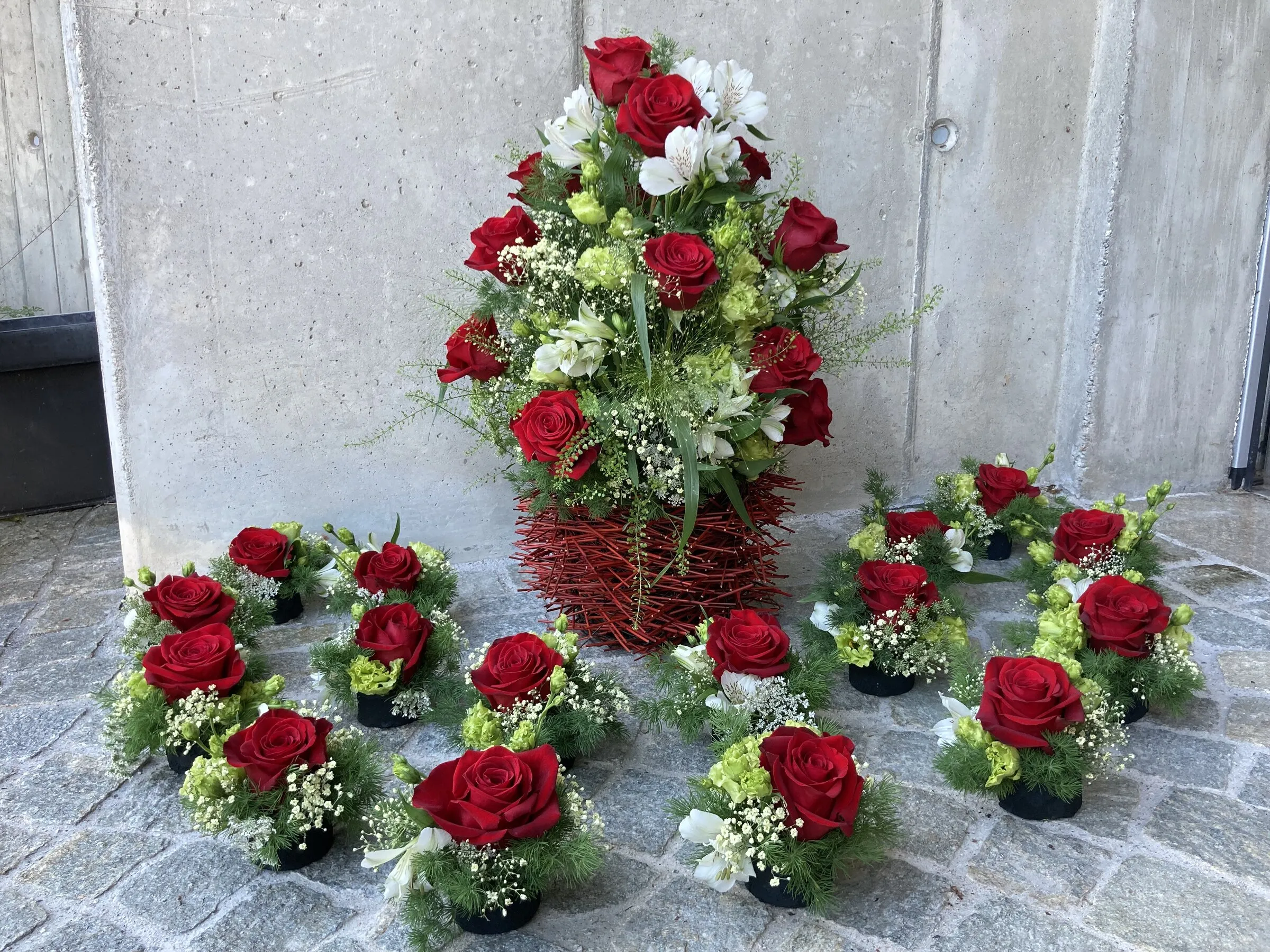 Hochzeitsfloristik mit roten Rosen – Hauptgesteck und passende kleine Tischgestecke