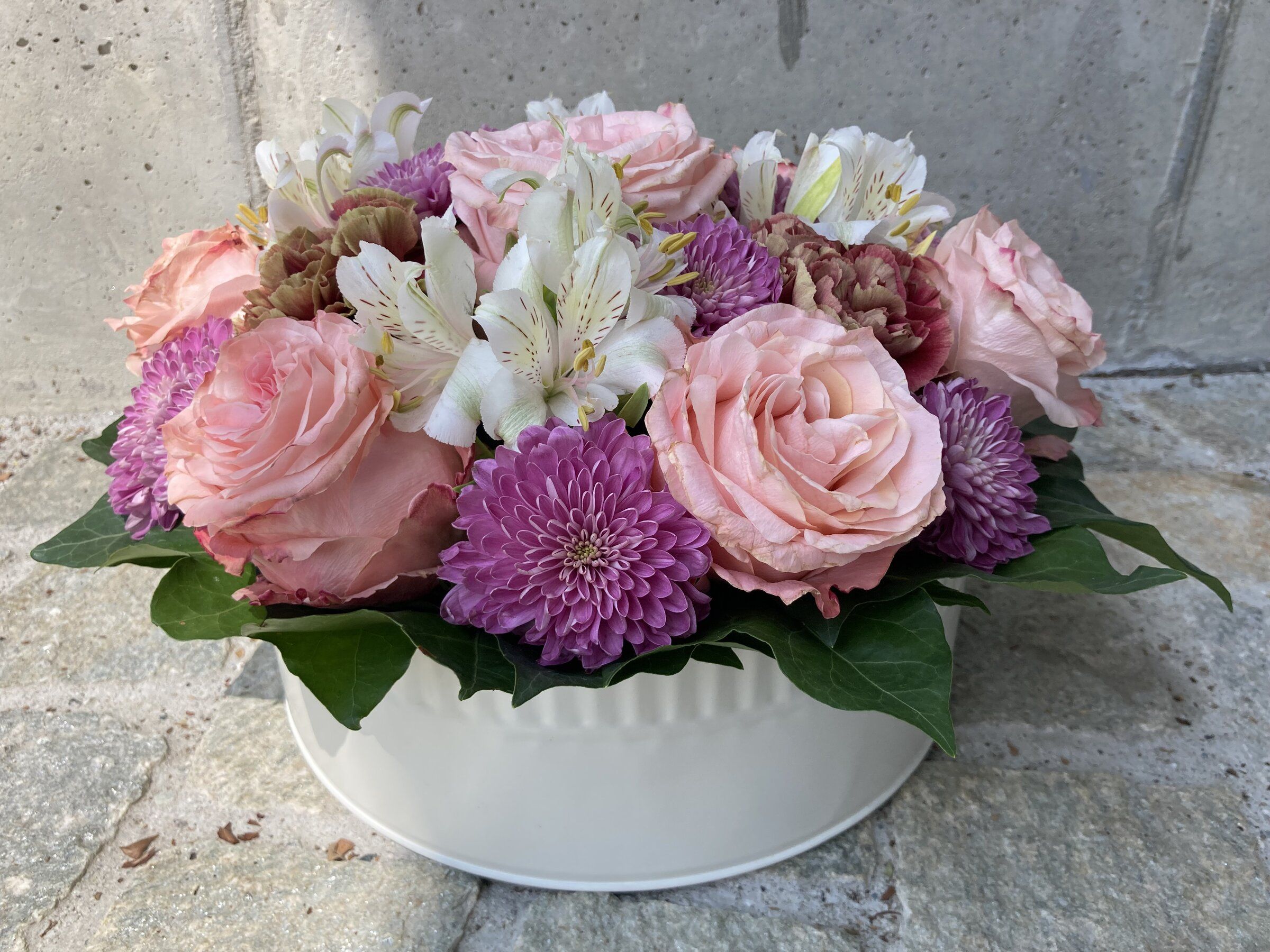 Weisse Ovalschale mit rosa Rosen, Alstroemerien und violetten Chrysanthemen