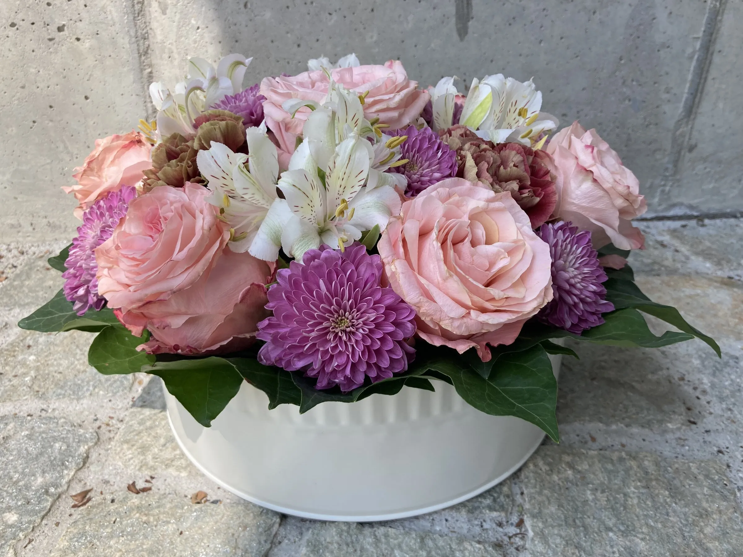 Weisse Ovalschale mit rosa Rosen, Alstroemerien und violetten Chrysanthemen