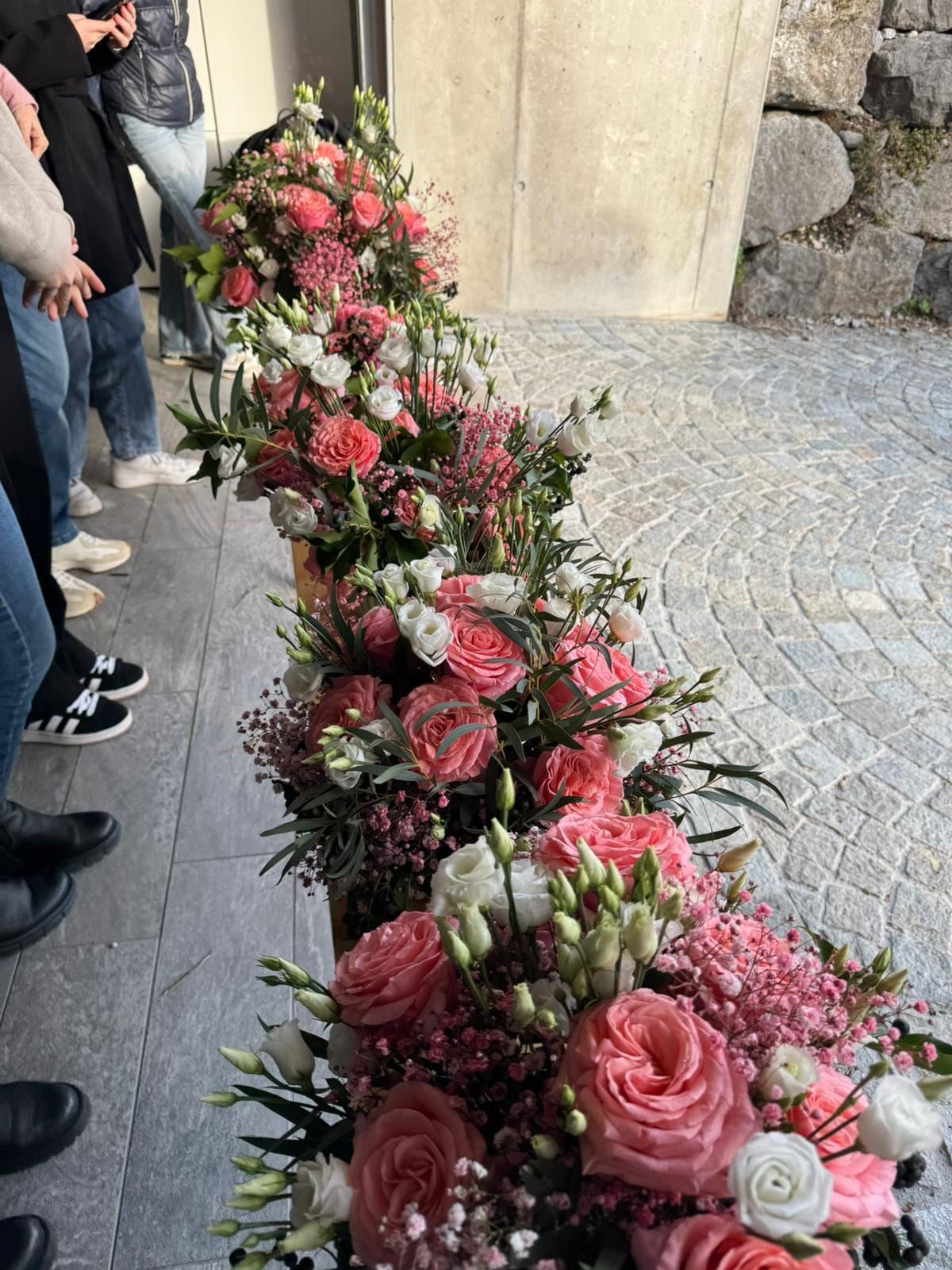 Aus einzelnen Werkstücken zusammengesetzte Blumengirlande in Rosa und Weiss