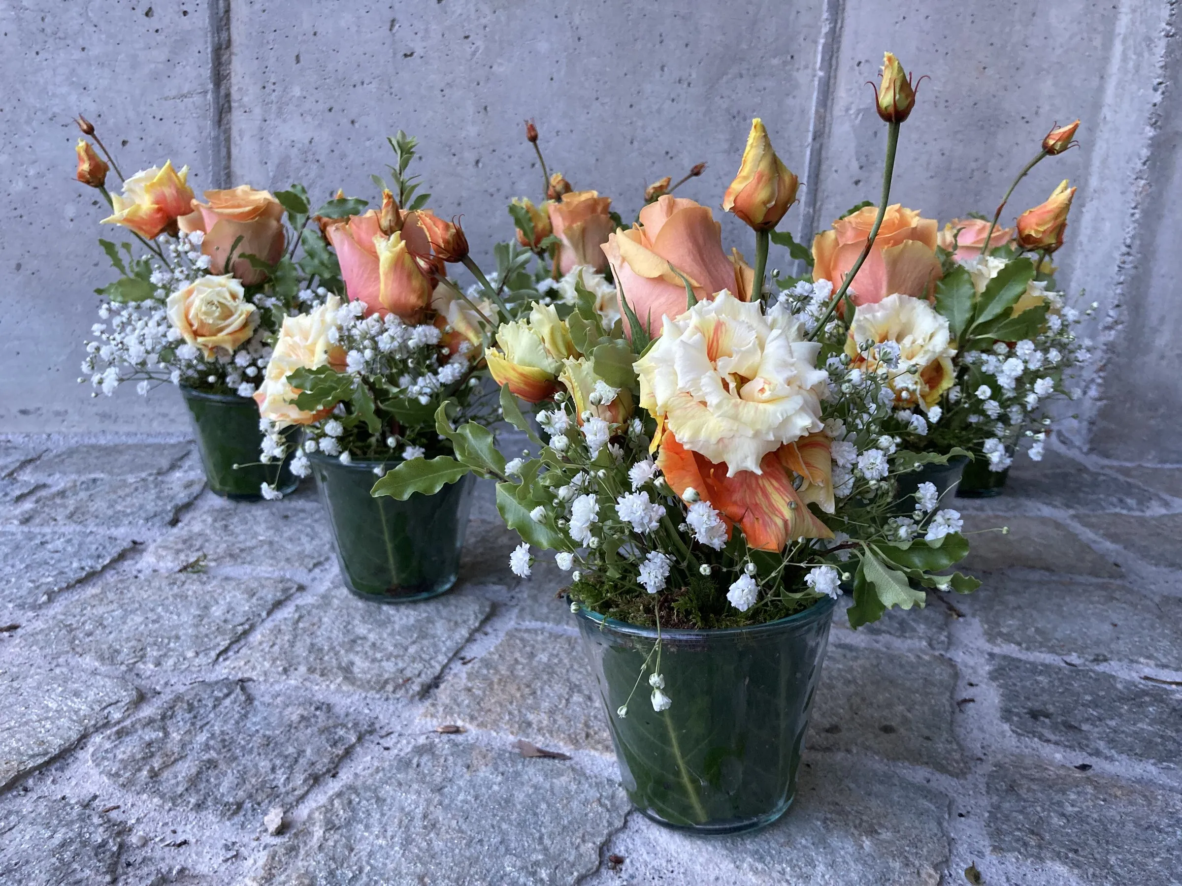Mehrere Zinkeimer mit apricotfarbenen Rosen und Schleierkraut